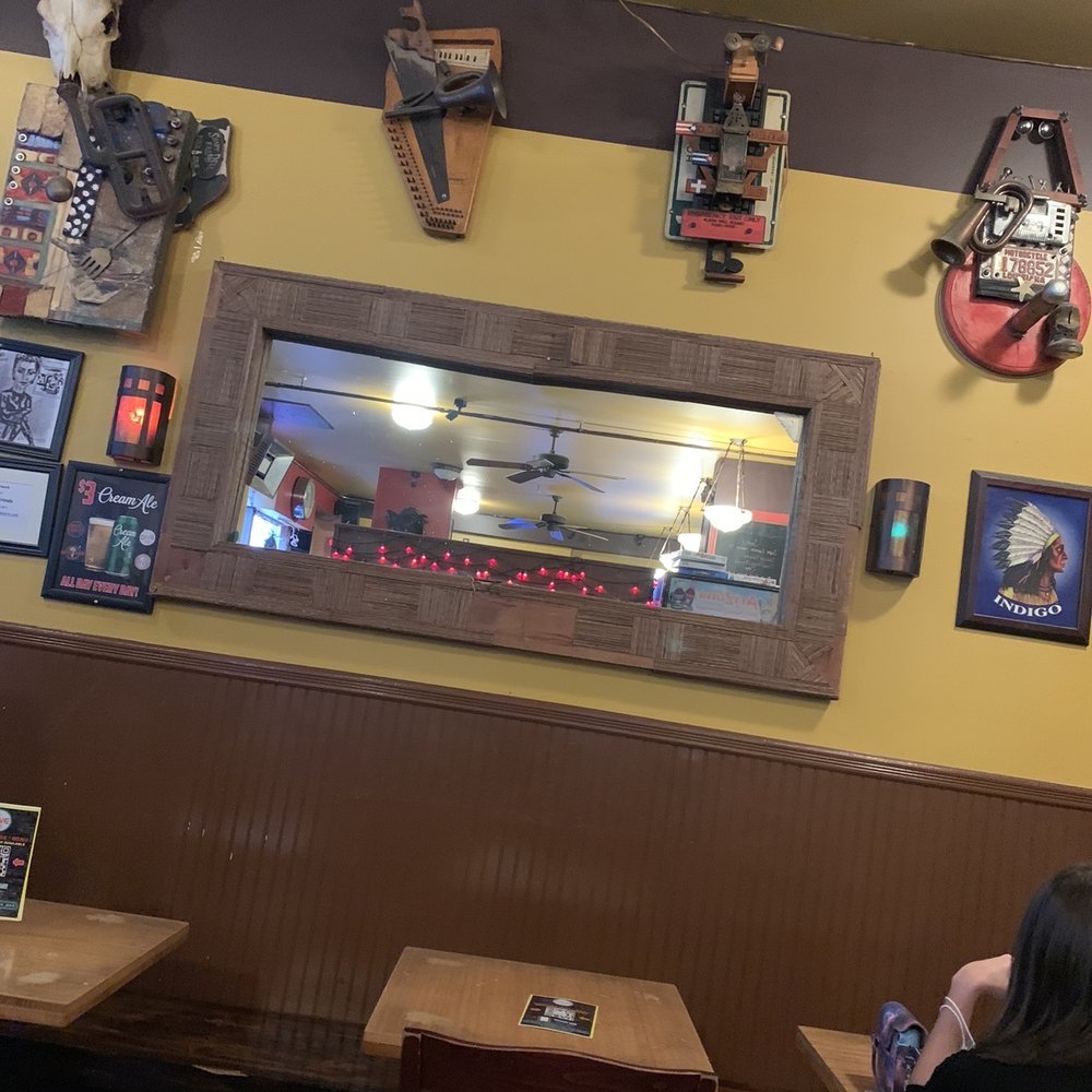 Dive 75 - a woman sitting at a table in a restaurant - Dive Bars Near Me - New York, New York