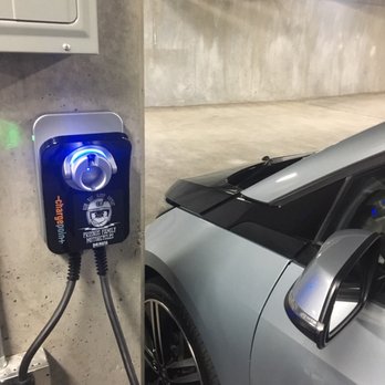 Value Electrical Construction - an electric car plugged into a charging station - Electricians Near Me