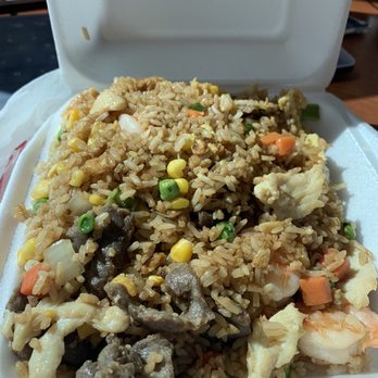 Lucky Wok - Combo fried rice - A foam takeout box contains fried rice mixed with vegetables, seafood, and meat, typical of Chinese cuisine takeout. - Chinese Near Me - Albuquerque, New Mexico