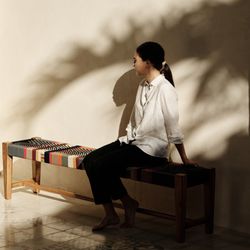 MasayaCo - A woven teak bench bathed in golden light -- where craft meets quiet reflection.