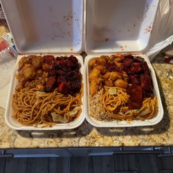Fresh Wok - Two plates; one with chow mien, the other half rice half chow mien, both with orange chicken and bbq pork