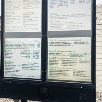 Subway - a menu on a sign in front of a brick building - Sandwiches Near Me - Holland, Michigan Subway - a menu on a sign in front of a brick building - Sandwiches Near Me - Holland, Michigan