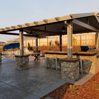 AAA Construction Services - Freestanding gabled patio cover with pan roof. Equipped with ceiling fans. Finished with stone pillars. Covering a built in bbq and kitchen. - Patio Coverings Near Me - Sacramento, California AAA Construction Services - Freestanding gabled patio cover with pan roof. Equipped with ceiling fans. Finished with stone pillars. Covering a built in bbq and kitchen. - Patio Coverings Near Me - Sacramento, California