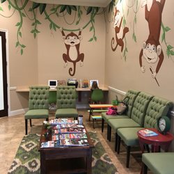 Woodforest Pediatric Dentistry - The waiting room has a table for coloring, iPads for the kids to play on and a movie running.