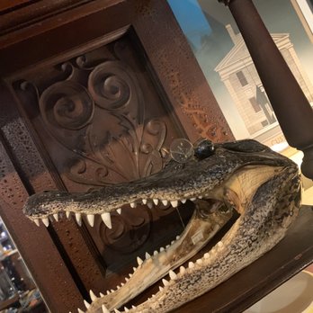 Diehl Marcus & Company - Smart gator - A crocodile head sculpture with open jaws and sharp teeth, decorated with glass orbs on its snout, placed on a wooden surface in an indoor setting. - Home Decor Near Me - Salem, Massachusetts