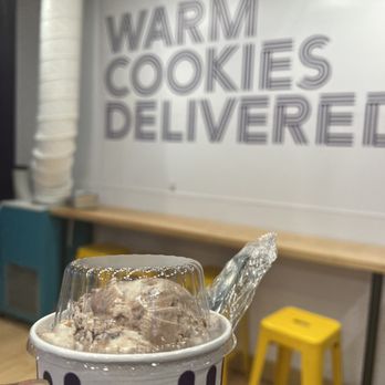 Insomnia Cookies - a hand holding a cup of ice cream - Bakeries Near Me - Fairfax, Virginia
