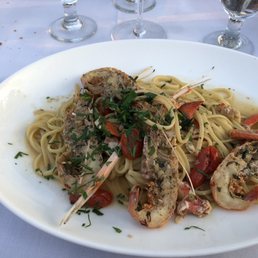 a plate of pasta with shrimp and tomatoes