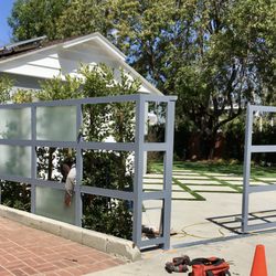 D L R Construction - New driveway features crisp concrete with grass inlays, paired with a modern frosted glass gate and a clean, low-maintenance lawn.