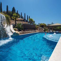 20x40 pool with 8 foot tall grotto waterfall, 30 foot waterslide from hot tub deck, sun shelf, and 4 seat swim-up bar.