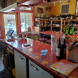 a red counter top with bottles of wine on it a red counter top with bottles of wine on it
