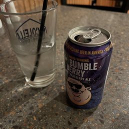 a can of kopper kettle and a glass of water