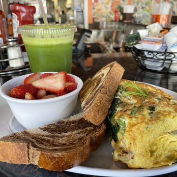 Two Chicks Cafe - Under The Sea Omelet with added mushroom and spinach plus fruit bowl and rye toast on the side. Also with Green Blast Cold Pressed Juice - Breakfast & Brunch Near Me - New Orleans, Louisiana Two Chicks Cafe - Under The Sea Omelet with added mushroom and spinach plus fruit bowl and rye toast on the side. Also with Green Blast Cold Pressed Juice - Breakfast & Brunch Near Me - New Orleans, Louisiana