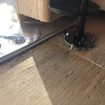 Amish Mike - A metal hinge and screw are mounted on a wooden surface, with some debris and a reflective surface nearby. - Building Supplies Near Me - Hackettstown, New Jersey