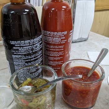 Pho Pasteur - Pho Pasteur condiments selection: hoisin, sriracha, pickled chilis, and chili sauce - Vietnamese Near Me - Toronto, Ontario