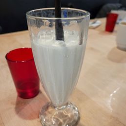 vanilla milkshake split into two glasses vanilla milkshake split into two glasses
