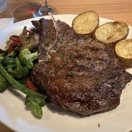 18oz Aged Bone-In Ribeye with mixed vegetables and roasted potatoes. 18oz Aged Bone-In Ribeye with mixed vegetables and roasted potatoes.