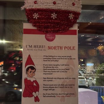 Rosa Mexicano - A Christmas ornament decorates a sign about Santa Claus at Rosa Mexicano in Hackensack, NJ, with a background of a window and city lights. - Mexican Near Me - Hackensack, New Jersey