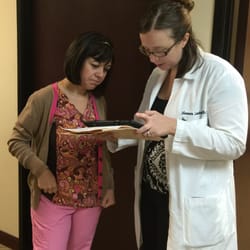 Ms. Lambert confers with Helen a medical assistant regarding patient care