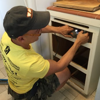 Flooring Genius - a man working on a stove - General Contractors Near Me