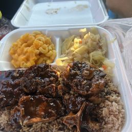 Oxtail Plate on a bed of rice, with Macaroni and cheese, and cabbage