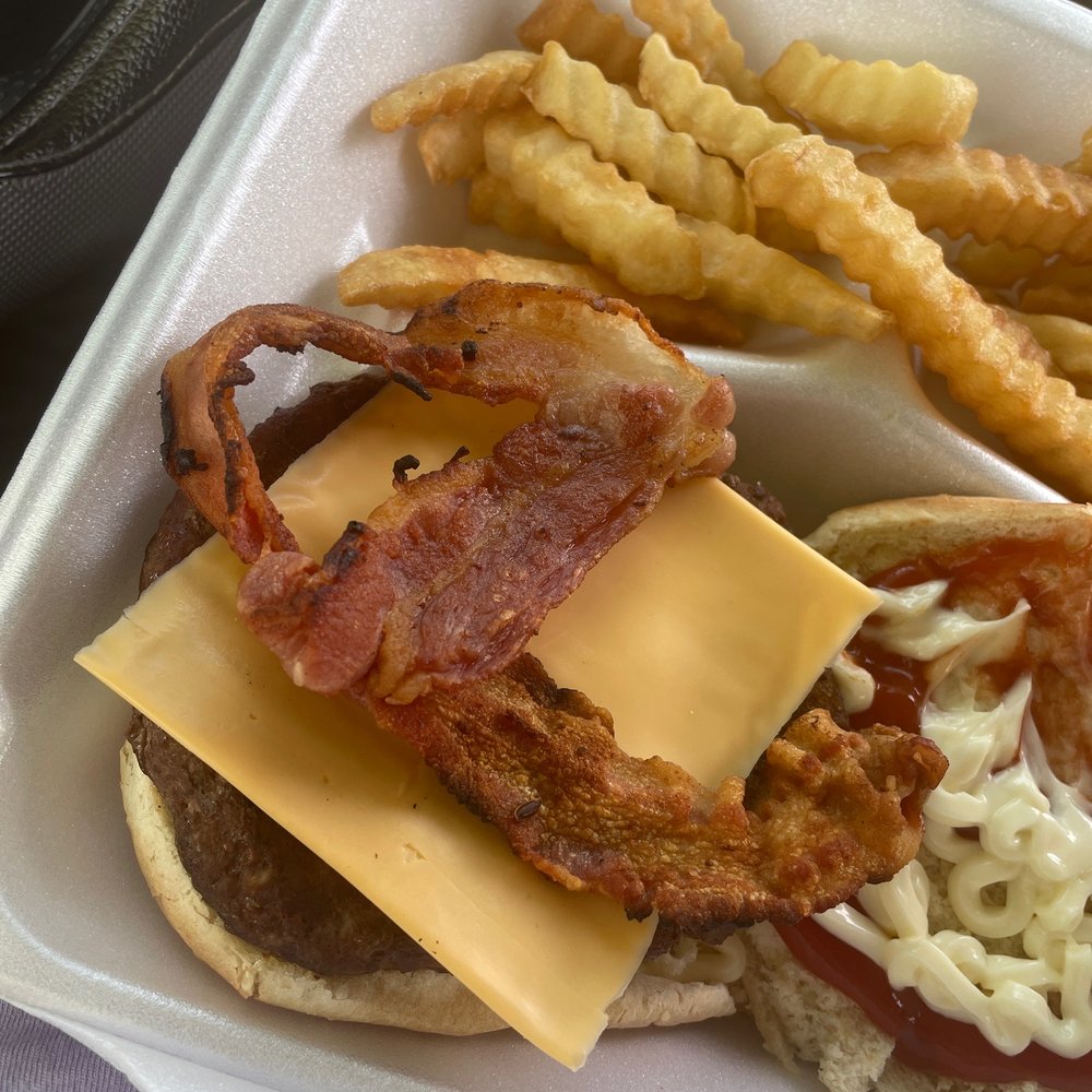 a cheeseburger with bacon, cheese, and french fries