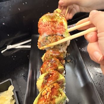 Yoshi Sushi - This Hell Roll. Very flavor full! Packed and squared cut. With peanut topped crunch and ell sauce. - Sushi Bars Near Me - Palmdale, California