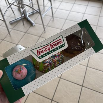 Krispy Kreme - a hand holding a box of krispy kreme doughnuts - Donuts Near Me - Decatur, Alabama