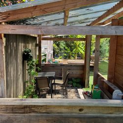 Overlook Collaborative Preschool - Inside the playhouse, where there is a table chairs, and a workbench with tools.