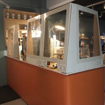 Full Stop - A counter with clear acrylic or glass barriers separates staff from customers, likely in a cafe or restaurant setting. - Coffee & Tea Near Me - Toronto, Ontario