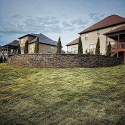 Nickens Outdoor Solutions - Retaining wall with sod , and arborvitae
