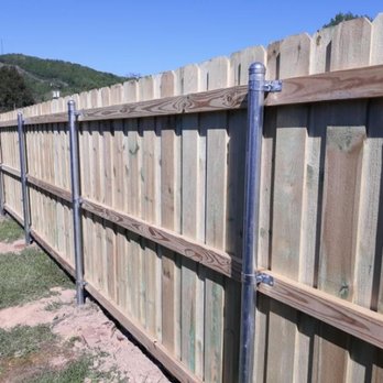 Johnson Contracting - a wooden fence with metal posts - Landscaping Near Me