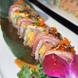 a plate of sushi with a flower on the side