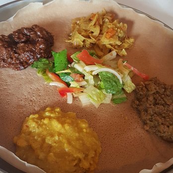 Demera - Clockwise from top left: Lamb, cabbage & potatoes, ground beef, split yellow peas - Ethiopian Near Me - Chicago, Illinois Demera - Clockwise from top left: Lamb, cabbage & potatoes, ground beef, split yellow peas - Ethiopian Near Me - Chicago, Illinois