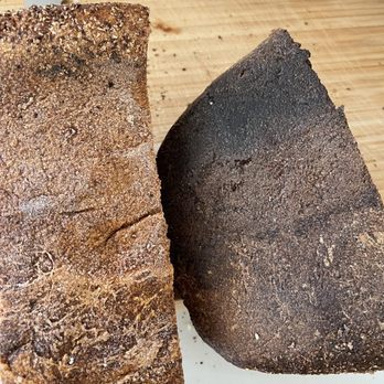 Faria Bakery - Bottom of two different batches of the wheat loaf. The right is burned. And tastes it unfortunately. - Bakeries Near Me - Sacramento, California
