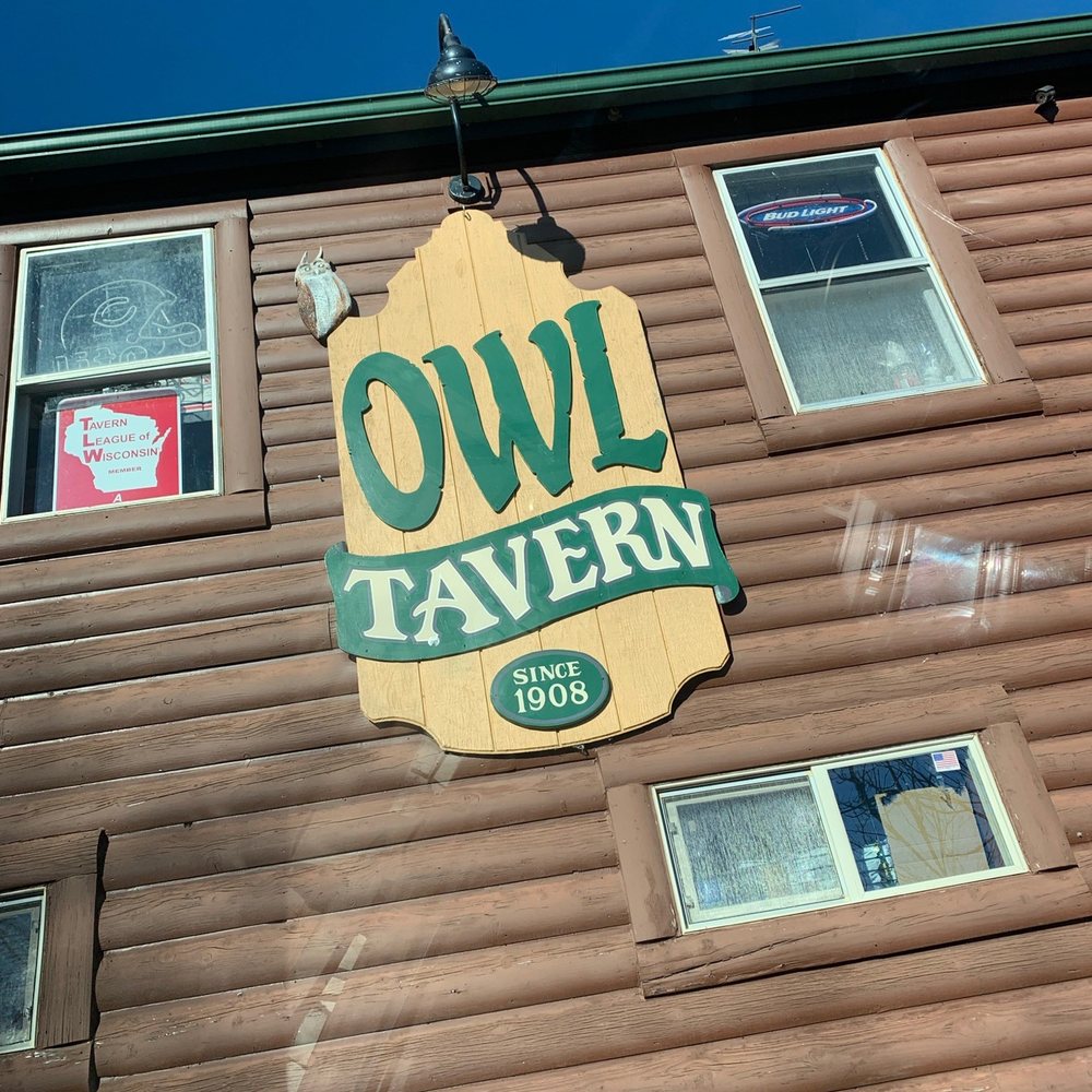 the owl tavern sign on the side of the building