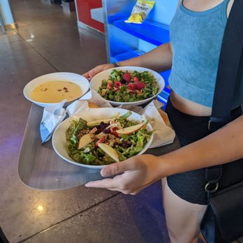 Café Zupas - a woman holding a tray of food - Sandwiches Near Me - West Valley, Utah Café Zupas - a woman holding a tray of food - Sandwiches Near Me - West Valley, Utah