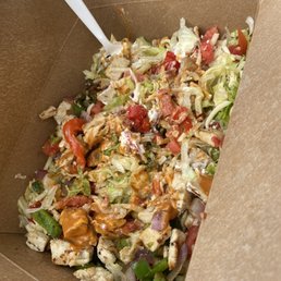 a salad in a box with a spoon