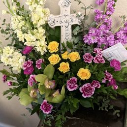 Gorgeous arrangement with stunning orchids and a ceramic cross!