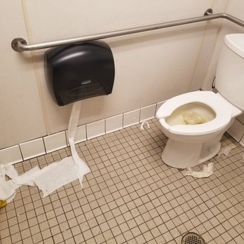QFC - a toilet with a roll of toilet paper on the floor - Grocery Near Me - Tacoma, Washington