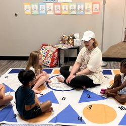 Calculating Minds Math Learning Center - Preschool students gather on a colorful math mat