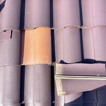 Regal Roofing Solutions - He replaced the broken tile. - A roof with purple tiles shows one broken tile and a piece of metal flashing, indicating roof repair work. - Roofing Near Me