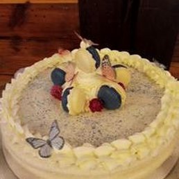 a white cake with blueberries and raspberries on top
