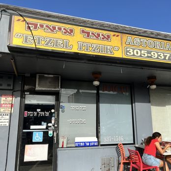 Etzel Itzik Deli - a woman sitting at a table - Delis Near Me - Miami, Florida
