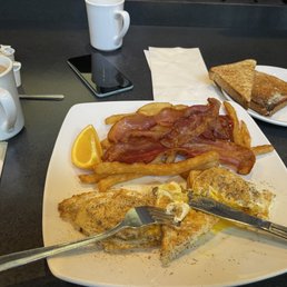 Two eggs with bacon, brown toast, fries and coffee Two eggs with bacon, brown toast, fries and coffee