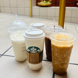 three cups of iced coffee on a tiled floor three cups of iced coffee on a tiled floor