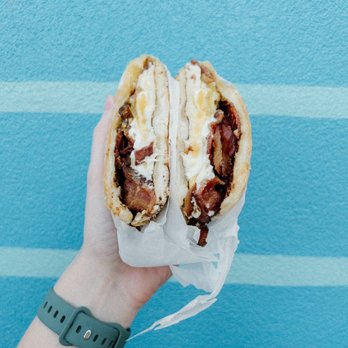 Bodega - a person holding a sandwich in their hand - Sandwiches Near Me - Charleston, South Carolina