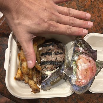 Banyans Craft Kitchen and Lounge - "1/2" of the burger we took home - hand (and To- go box) for scale. - Lounges Near Me - Kailua, Hawaii