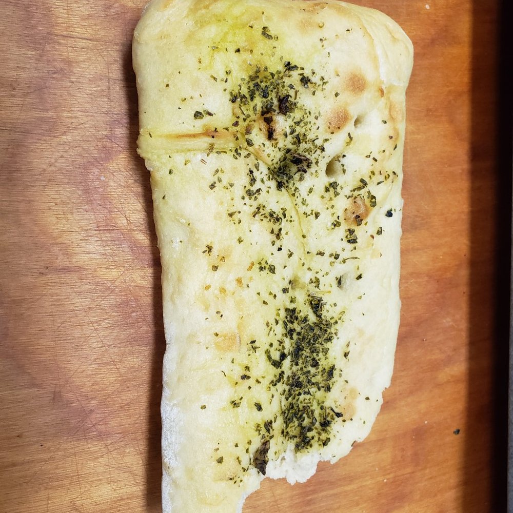 Cobs Bread - a piece of bread on a cutting board - Bakeries Near Me - Surrey, British Columbia