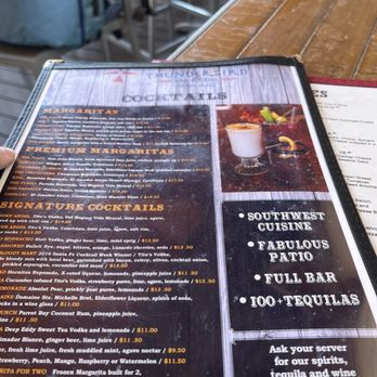 Thunderbird Bar & Grill - Their menu as of May 19th, 2024 - A menu featuring cocktails and margaritas is placed on a wooden table at Thunderbird Bar & Grill in Santa Fe, NM. - American Near Me - Santa Fe, New Mexico