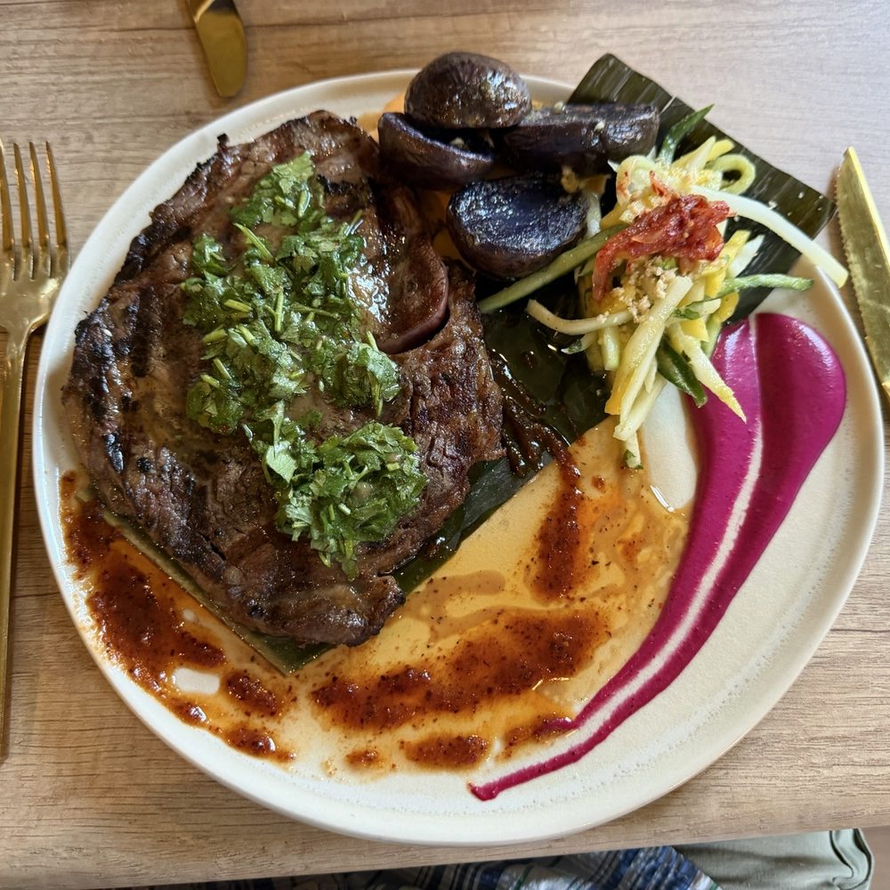 Naz - Ribeye with bone marrow reduction sauce, red potatoes and shredded vegetables.  The flavors were incredible! - Peruvian Near Me - Ashland, Oregon